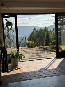 an open glass door with a view of a patio at Hotel Horní Pramen in Špindlerův Mlýn