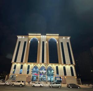 a large building with cars parked in front of it at فندق التاج ثلاثة مكة in Mecca