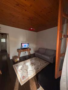 ein Wohnzimmer mit Sofa und Fernseher in der Unterkunft Casa Encanto de Lavras Novas - MG in Lavras Novas