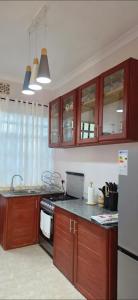 アルーシャにあるEuro Luxe Apartmentsの木製のキャビネットと白い冷蔵庫を備えたキッチン