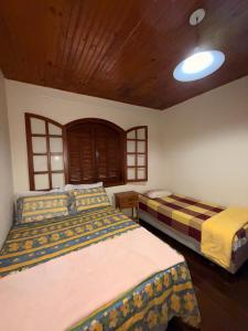 ein Schlafzimmer mit zwei Betten und einer Holzdecke in der Unterkunft Casa Encanto de Lavras Novas - MG in Lavras Novas