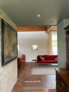 a living room with a red couch and a table at The Barns Low Stott Park near Lake Windermere in Ulverston