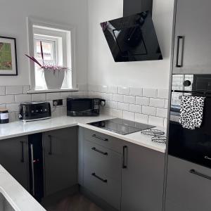 a kitchen with a sink and a stove at No 6 Harrogate Luxury Boutique Home in Harrogate