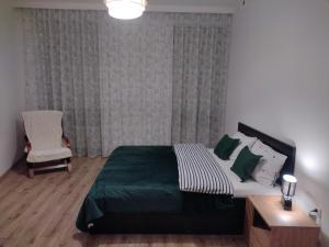 Un dormitorio con una cama grande y una silla. en Mieszkanie Grodzka 17 Przemyśl Polska, en Przemyśl