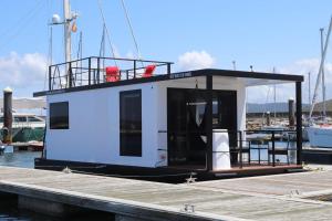 a small white boat sitting at a dock at Alma Flotante Muxía in Muxia