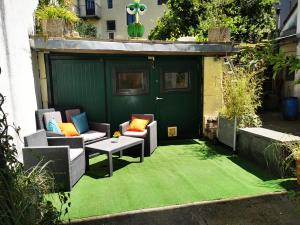 patio z 2 krzesłami i stołem na zielonym dywanie w obiekcie Zentrale, ruhige Wohnung nahe Murinsel & Kunsthaus w Grazu
