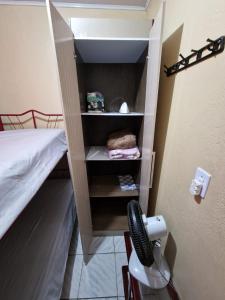 a room with a bed and a closet with a hair dryer at FLAT CENTRAL- Ar-Condicionado-Estacionamento in Feira de Santana +15 photos