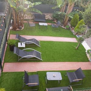 a group of chairs and tables on a lawn at TROPICAL HOME PORTO CERESIO in Porto Ceresio