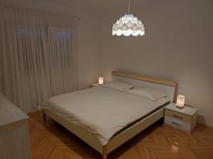 a bedroom with a bed with two candles on it at Apartman Doma in Livno