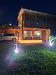 Una motocicleta estacionada frente a una casa por la noche en Casa Carballo, en Puxedo