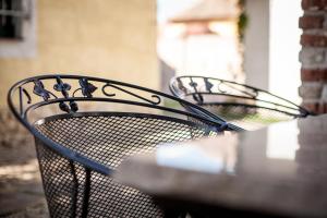 two metal benches sitting next to a table at Lichtenštejnské domky in Lednice