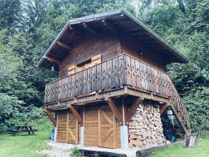 a large wooden cabin with a pile of wood at Mazot du Bois in Les Houches