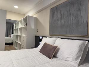 a bedroom with a white bed with a large painting on the wall at Luxury Tower Top Floor Apartment in Arequipa
