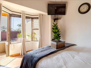 a bedroom with a bed and a clock on the wall at Amalfi Place in Pretoria +11 photos