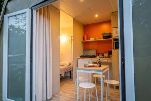 a small kitchen with a small table and stools at Camping Onlycamp La Potinière in Écueillé