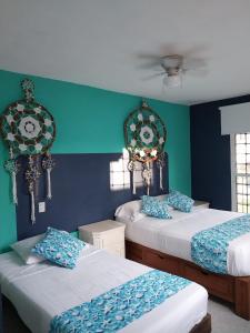 two beds in a room with blue and green walls at Casa de 4 habitaciones con alberca in Barrio Nuevo