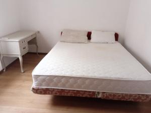 a bed in a room with a desk and a mattress at Braco apartmani Utjeha in Kravlja