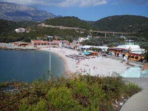 a beach with a bunch of people on the beach at Braco apartmani Utjeha in Kravlja