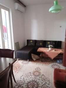 a living room with a couch and a table at Braco apartmani Utjeha in Kravlja +12 photos