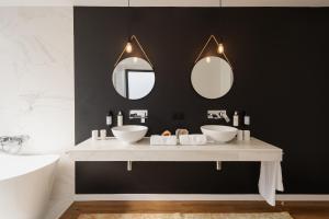 a bathroom with two sinks and two mirrors at Quinta do Rosário in Lagoa +18 photos