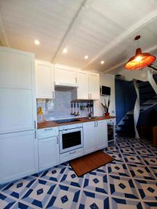 a kitchen with white cabinets and a tile floor at MinaMare Vacation Home in Torre Annunziata