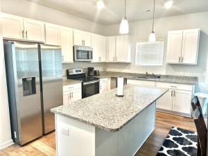 cocina con armarios blancos y encimera de granito en Beautiful Spacious Family-Friendly Home, en Winston-Salem 30 fotos más