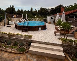 einen Pool im Garten mit Terrasse in der Unterkunft Apartmani Merica in Pakoštane