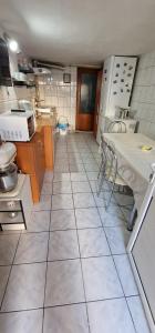 a kitchen with a tiled floor with a table and chairs at Casa Dorului in Mangalia