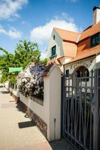 a fence in front of a building with flowers at Lichtenštejnské domky in Lednice