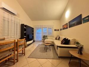 ein Wohnzimmer mit Couch und Fernseher in der Unterkunft Apartmani Merica in Pakoštane