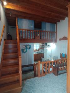 a living room with a staircase and a kitchen at Glaros Studios Agriolivadi Patmos in Patmos