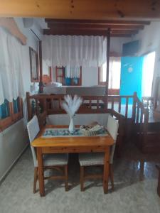 a dining room table with a vase of flowers on it at Glaros Studios Agriolivadi Patmos in Patmos