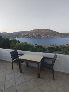 a table and two chairs on a balcony with a view at Glaros Studios Agriolivadi Patmos in Patmos