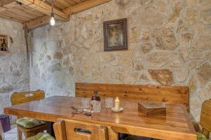 a stone wall with a wooden table with a candle at Villa Lara, Family Retreat with Sea View & Pool in Sveti Filip i Jakov