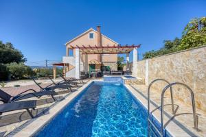 a swimming pool with chairs and a gazebo at Villa Lara, Family Retreat with Sea View & Pool in Sveti Filip i Jakov