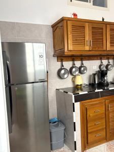a kitchen with a stainless steel refrigerator and wooden cabinets at Chez hamid in Oualidia +7 photos