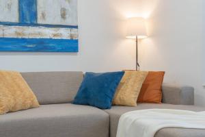 a couch with pillows on it in a living room at Private neat and cozy room with shared living room and kitchen in Calgary +1 photo