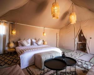 Un dormitorio con una cama en una tienda de campaña. en Africa Luxury Camp, en Merzouga