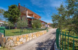 a house with a green fence next to a road at Villa Lara, Family Retreat with Sea View & Pool in Sveti Filip i Jakov