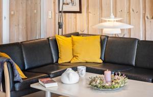 a black leather couch with yellow pillows and a table at Beautiful Home In Sydals With Sauna in Sarup