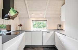 a kitchen with white cabinets and a sink at Beautiful Home In Sydals With Sauna in Sarup +16 photos