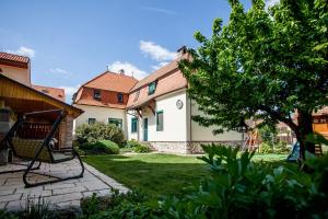 a yard with a swing in front of a house at Lichtenštejnské domky in Lednice