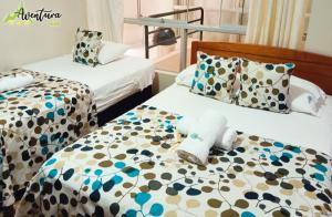 two beds in a hotel room with towels on them at Destino Aventura Peru in La Merced +15 photos