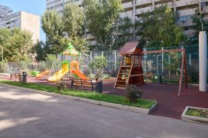 One Bedroom Apartment Next to Arbat In The Center of Almaty في ألماتي: ملعب مع زلاجة وهيكل لعب
