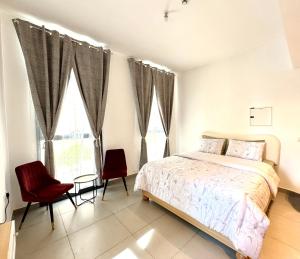 沙迦The Cosy Loft的一间卧室,有一张床和两把红椅子