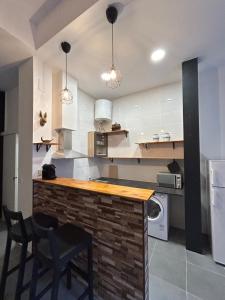 a kitchen with a counter with chairs and a microwave at MaiFamilyBCN-Cómodo Y Para familia Y Metro Cercano in Badalona