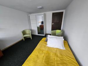 a hotel room with a bed and two chairs at Apartament Ogrodowa in Biała Podlaska