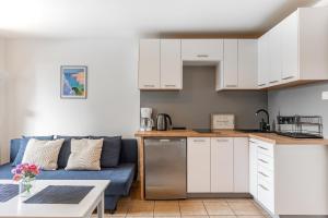 una cucina e un soggiorno con divano blu di Domek nad wodą a Kamień Pomorski