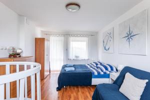 una camera da letto con un letto e un divano di Domek nad wodą a Kamień Pomorski