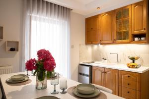 a kitchen with a table with a vase of flowers on it at Thea 1 in Leptokarya